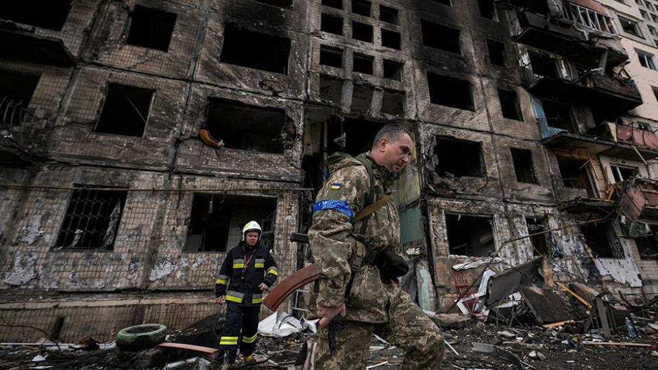 Ukrainian soldiers and firefighters search in a destroyed building after a bombing attack in Kyiv
