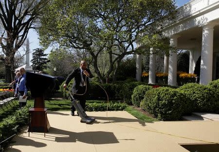 A member of the White House staff vacuums the podium before Judge Neil Gorsuch is sworn in as an Associate Supreme Court Justice in the Rose Garden of the White House in Washington, U.S., April 10, 2017. REUTERS/Joshua Roberts