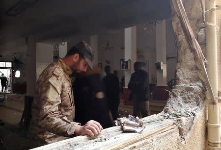 A member of the Libyan National Army inspects the damage following a twin bombing inside a mosque in Benghazi, Libya February 9, 2018. REUTERS/Stringer