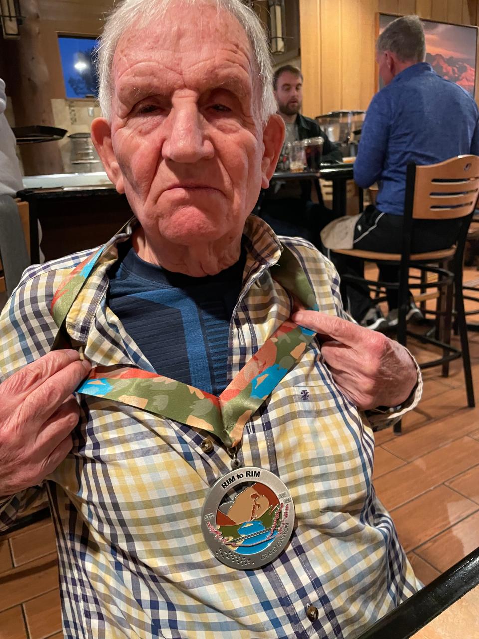 Alfredo Aliaga Burdio, 92, poses with a medal commemorating his 24-mile hike of the Grand Canyon on Oct. 14 and 15, 2023.