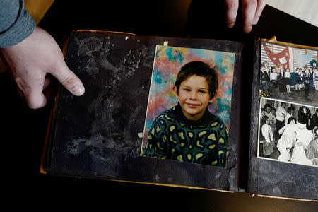 Mariusz Milewski, 28, shows his photo album with a picture from when he was in primary school at his house in Wardegowo village, Poland, February 17, 2019. Picture taken February 17, 2019. REUTERS/Kacper Pempel