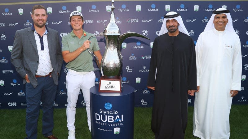 Chris Kirchner (majtas majtas) qëndron pranë Viktor Hovland të Norvegjisë i cili mban trofeun e tij në Slync.io Dubai Desert Classic në Emirates Golf Club më 30 janar 2022 në Dubai, Emiratet e Bashkuara Arabe.