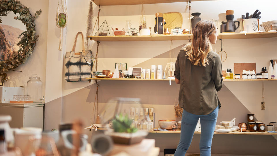 Rearview shot of a young woman looking at products on a shelf in a store.