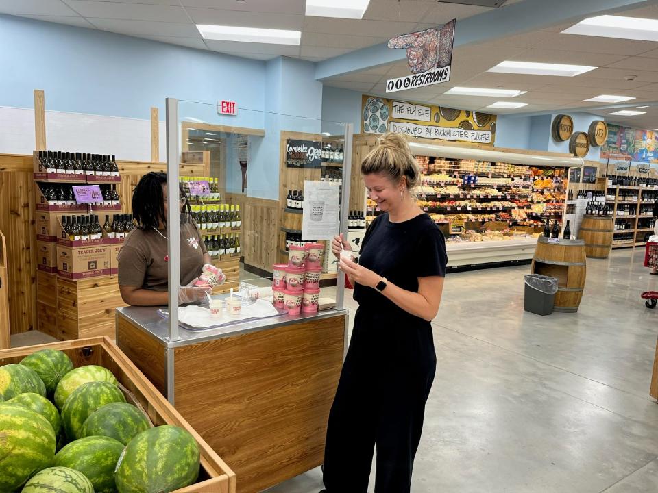 The author taking a sample from a worker who is standing at the Trader Joe's sampling bar