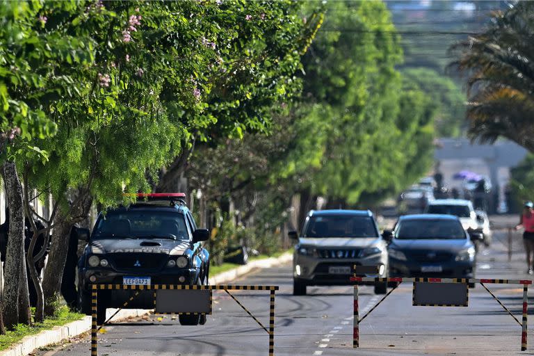 Un vehículo de la Policía Federal está estacionado dentro del condominio donde vive el expresidente brasileño Jair Bolsonaro, después de supuestamente registrar su casa como parte de una investigación sobre acusaciones de falsificación de certificados de vacunación contra la COVID-19, en Brasilia el 3 de mayo de 2023