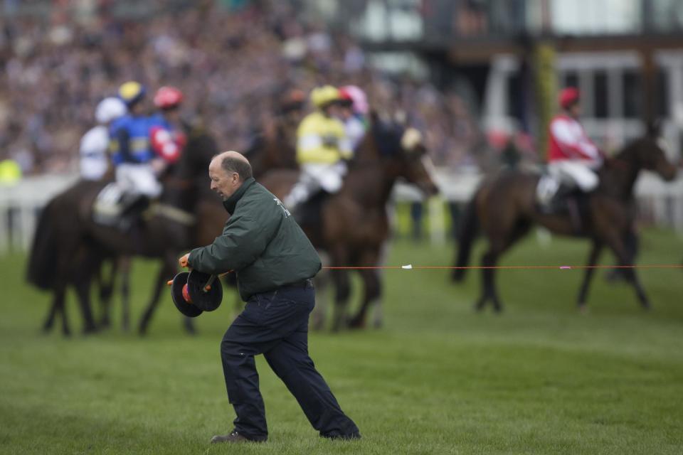 Starting tape is stretched across the course after a false start to the Grand National horse race at Aintree Racecourse Liverpool, England, Saturday, April 5, 2014. (AP Photo/Jon Super)