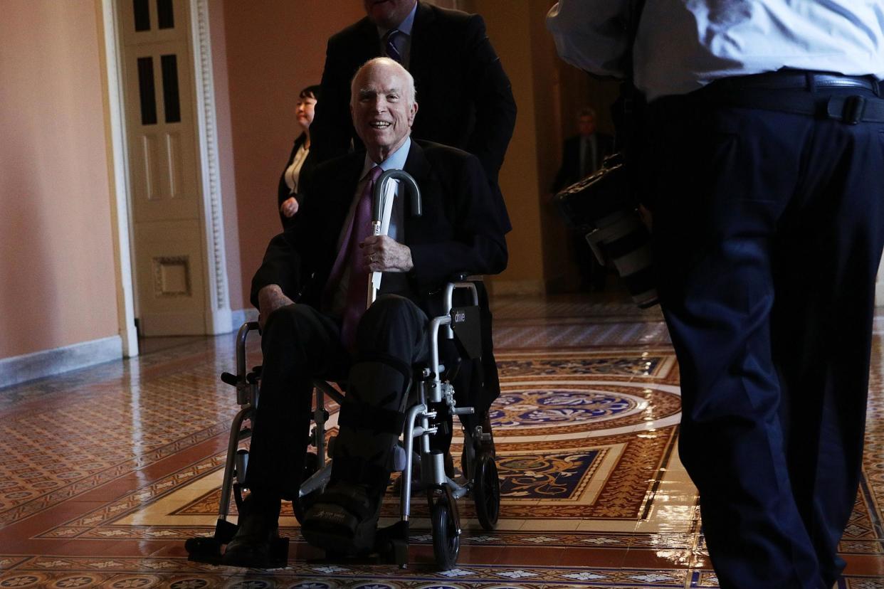 US Sen. John McCain passes by on a wheelchair in a hallway at the Capitol: Alex Wong/Getty Images