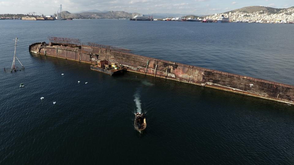 A dinghy with workers leaves from Damari, an area with eleven shipwrecks, on Salamina island, west of Athens, on Wednesday, Feb. 13, 2020. Greece this year is commemorating one of the greatest naval battles in ancient history at Salamis, where the invading Persian navy suffered a heavy defeat 2,500 years ago. But before the celebrations can start in earnest, authorities and private donors are leaning into a massive decluttering operation. They are clearing the coastline of dozens of sunken and partially sunken cargo ships, sailboats and other abandoned vessels. (AP Photo/Thanassis Stavrakis)