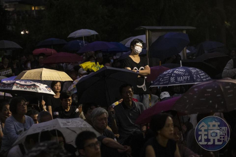 集會中一度下起大雨，部分人撐起雨傘，但無人離開。