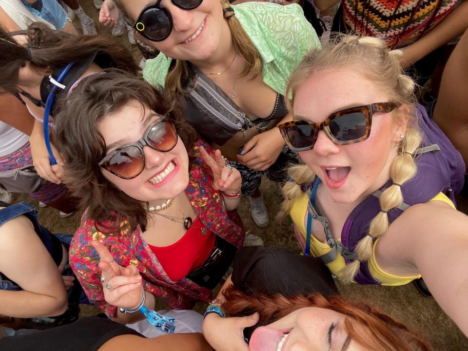 People pose for a photo in a crowd at a music festival.