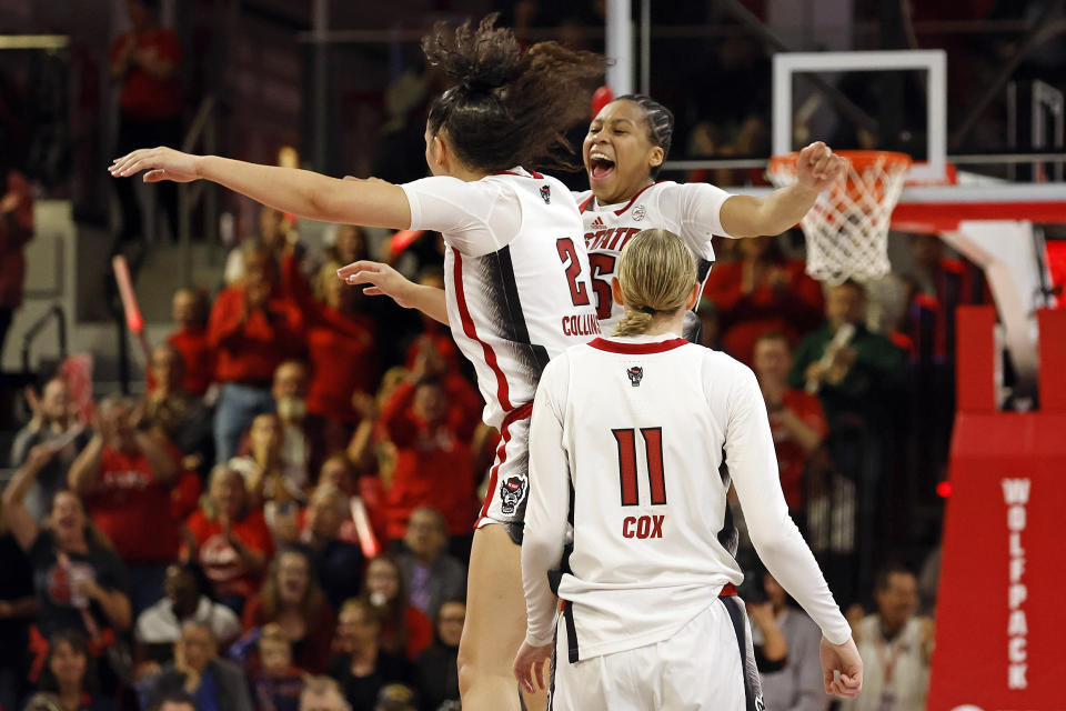 North Carolina State's Zoe Brooks, top right, jumps and celebrates with Mimi Collins (2) with Maddie Cox (11) nearby during the second half of an NCAA college basketball game against UConn, Sunday, Nov. 12, 2023, in Raleigh, N.C. (AP Photo/Karl B. DeBlaker)