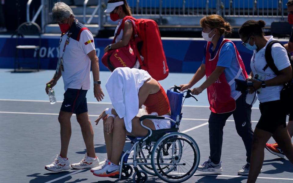Paula Badosa had to leave the court in a wheelchair after suffering in the heat - AP