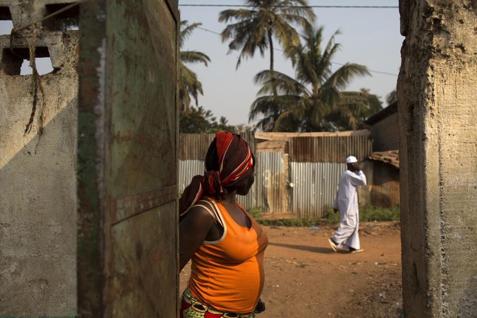 A woman looks at a man walking past from the entrance of a madrasa, hosting internally displaced persons (IDPs) in a Muslim neighbourhood in the capital Bangui