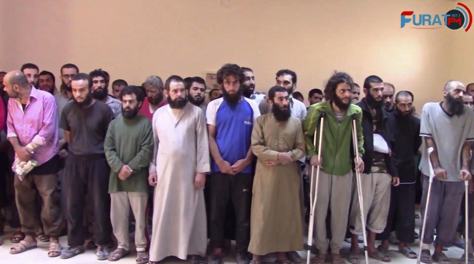 FILE - In this frame grab from video released In this Oct. 15, 2017 file photo and provided by Furat FM, a Syrian Kurdish activist-run media group, shows Syrian Islamic State group fighters who have surrendered, at a base of the U.S.-backed Syrian Democratic Forces (SDF), in Raqqa, Syria. A year after it was routed from Iraq following a three-year devastating war that left Iraqi cities in ruin, the Islamic State group is fighting to hang on to its last enclave in Syria, engaging in deadly battles with U.S.-backed forces in the country's east near the Iraqi border. (Furat FM, via AP, File)