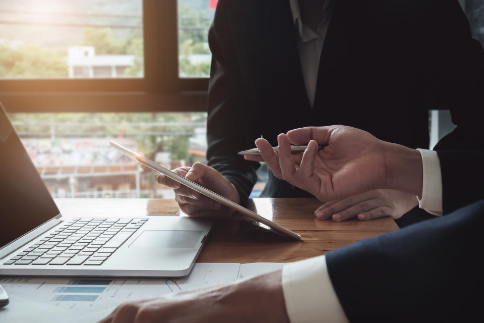 Investors review data on a tablet.