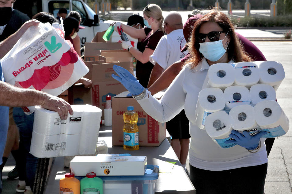 Volunteers prepare donations for delivery to those affected by COVID-19 on tribal lands Thursday, June 25, 2020, in Tempe, Ariz. The resource drive is for families isolated due to COVID-19 on Navajo, Hualapai, Havasupai and White Mountain Apache tribal lands. (AP Photo/Matt York)