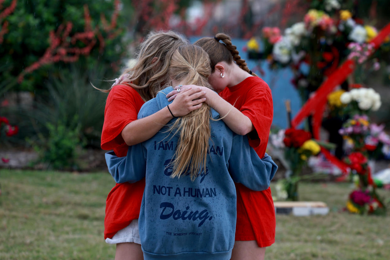 People pray during a visit to a memorial setup near an entrance to the Allen Premium Outlets mall after the mass shooting occurred on May 8, 2023 in Allen, Texas. (Joe Raedle/Getty Images)