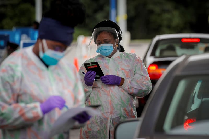 FILE PHOTO: Medical technicians work at a drive-through coronavirus disease (COVID-19) testing facility at the Regeneron Pharmaceuticals company's Westchester campus in Tarrytown, New York