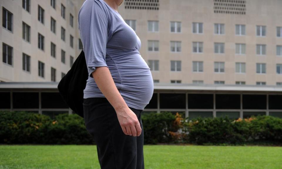 A pregnant woman walks past a government building in Washington DC