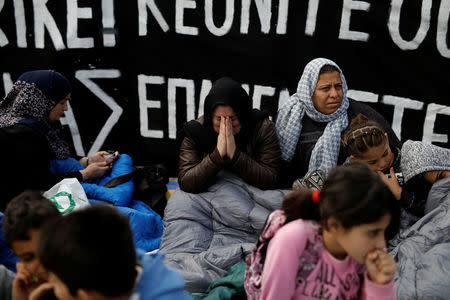 A woman cries in front of a banner announcing a hunger strike, as refugees seeking reunification with family members in Germany protest near the parliament building in Athens, Greece, November 1, 2017. REUTERS/Alkis Konstantinidis