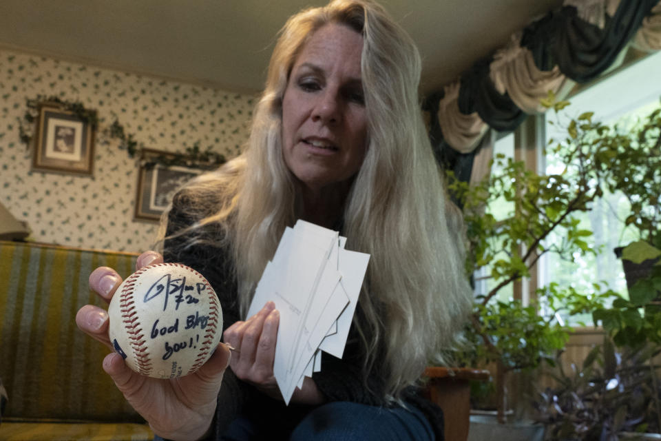 TeriAnn Reynolds holds a signed baseball from Major League Baseball player Donovan Solano on Thursday, April 27, 2023, in Johnson City, Tenn. The Reynolds hosted Solano and over 40 minor league baseball players from the Johnson City Cardinals in their home for more than 10 years. (AP Photo/George Walker IV)