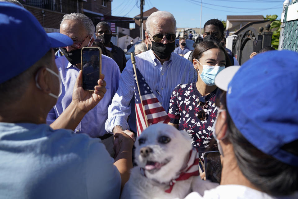 President Joe Biden talks with people as he tours a neighborhood impacted by flooding from the remnants of Hurricane Ida, Tuesday, Sept. 7, 2021, in the Queens borough of New York, with Senate Majority Leader Chuck Schumer of N.Y., and Rep. Alexandria Ocasio-Cortez, D-N.Y. (AP Photo/Evan Vucci)