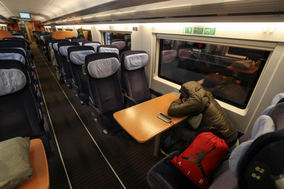 Ein gestrandeter Reisender schläft in einem abgestellten ICE am Kölner Hauptbahnhof. Die Deutsche Bahn stellte den Fernverkehr über die Nacht auf Montag komplett ein. (Bild: Reuters/Wolfgang Rattay)