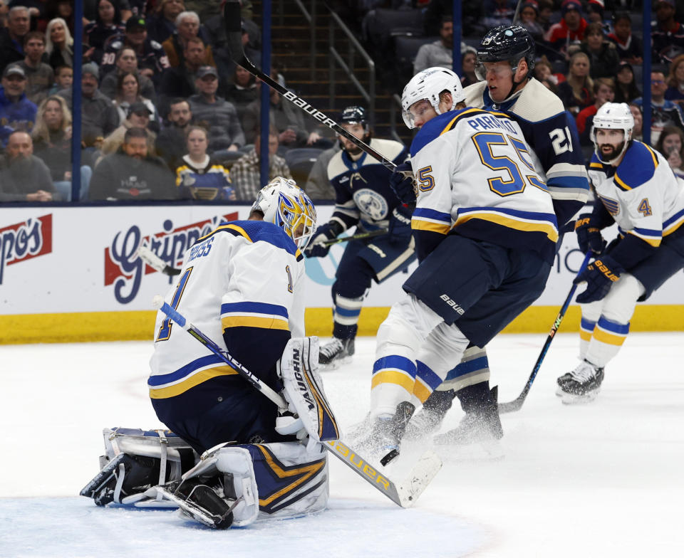 St. Louis Blues goalie Thomas Greiss, left, makes a stop in front of Columbus Blue Jackets forward Patrik Laine, right, and Blues defenseman Colton Parayko during the second period of an NHL hockey game in Columbus, Ohio, Saturday, March 11, 2023. (AP Photo/Paul Vernon)