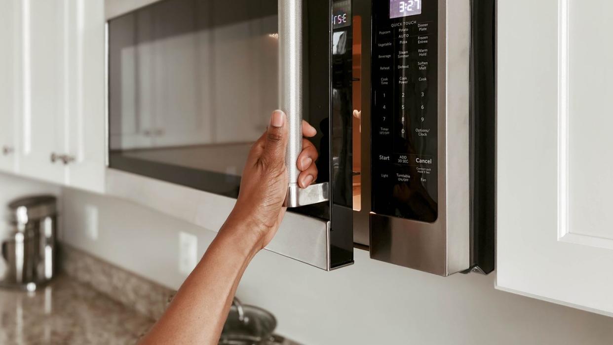 close up of woman opening microwave