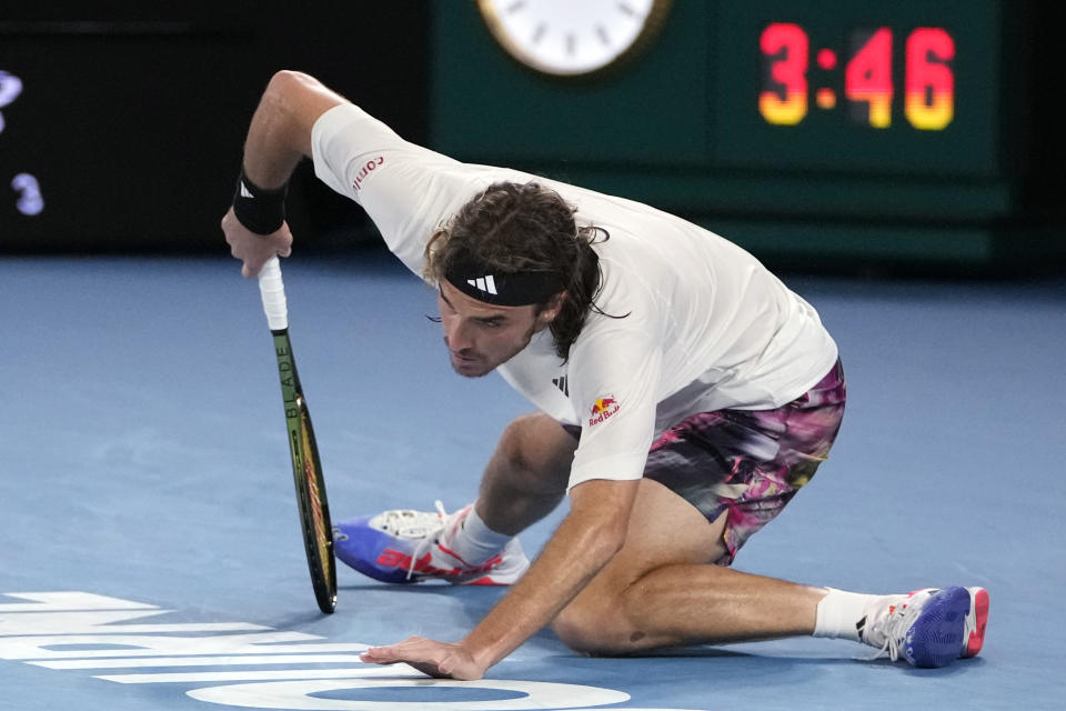 Stefanos Tsitsipas of Greece falls during his fourth round match against Jannik Sinner of Italy at the Australian Open tennis championship in Melbourne, Australia, Sunday, Jan. 22, 2023. (AP Photo/Mark Baker)