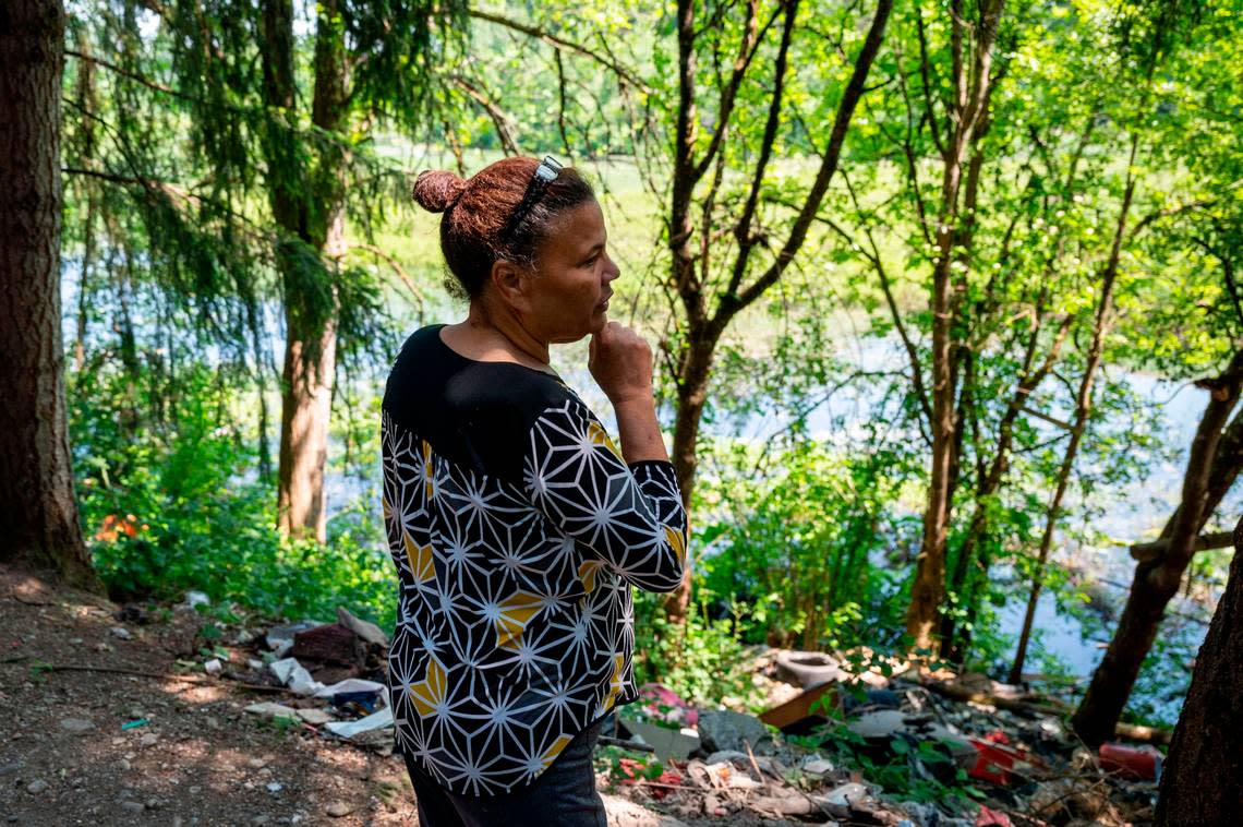 Bouviea Aaron, 65, stands along the eastern edge of a homeless encampment in the 9700 block of Steele Street South in Tacoma on Thursday, May 25, 2023. The encampment, informally known as “The Jungle,” is located around Charlton Lake on the far south side of Tacoma.