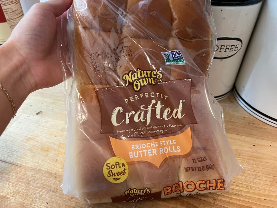 hand holding up a bag of nature's own butter rolls