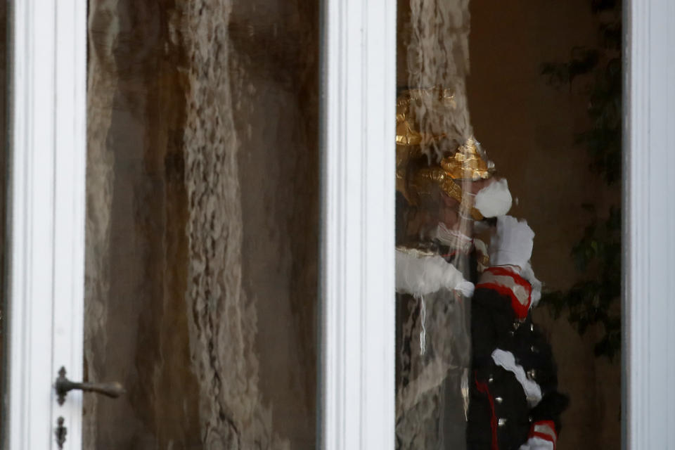 A Cuirassier Regiment presidential guard stands behind a window of the Quirinale presidential palace, in Rome, Wednesday, Jan. 27, 2021. Italian Premier Giuseppe Conte resigned after a key coalition ally pulled his party's support over Conte's handling of the coronavirus pandemic, setting the stage for consultations this week to determine if he can form a third government.(AP Photo/Alessandra Tarantino)