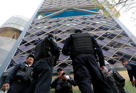 Police officers stand guard outside the tower after people were evacuated from the Mexican headquarters of Spain's BBVA due to what the bank said were two anonymous emails threatening violent acts against its corporate offices, in Mexico City, Mexico March 13, 2019. REUTERS/Henry Romero