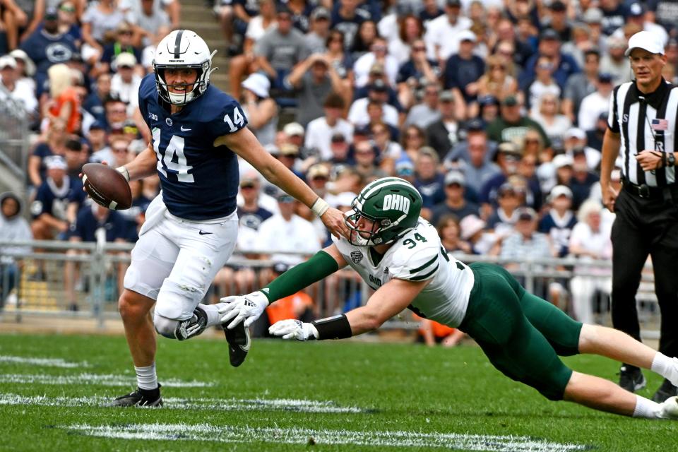 Penn State quarterback Sean Clifford (14) scrambles away from Ohio linebacker Dylan Stevens (34) in the first half of an NCAA college football game, Saturday, Sept. 10, 2022, in State College, Pa. (AP Photo/Barry Reeger)