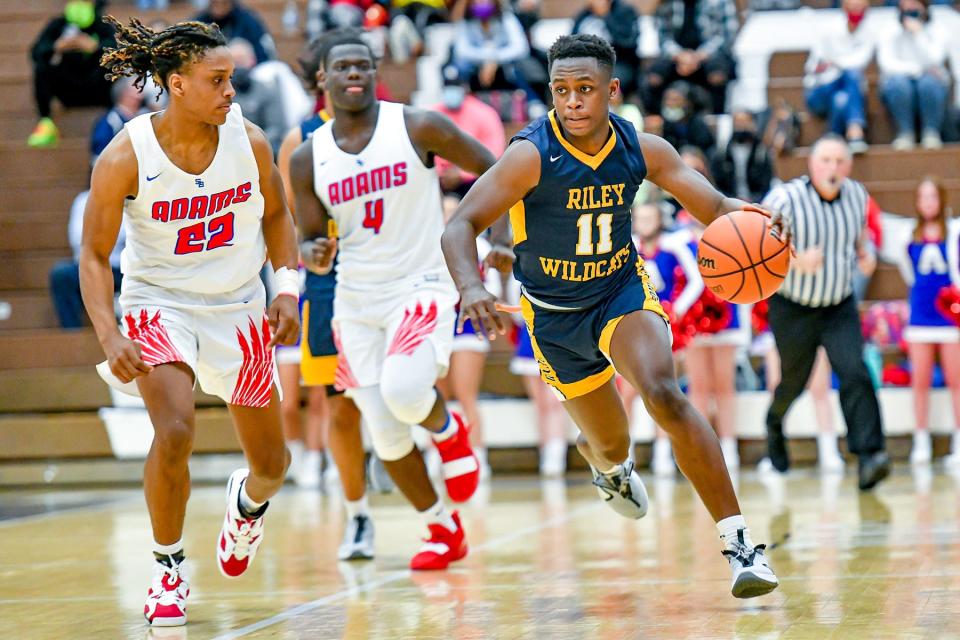 Riley's Isaiah Robinson (11) dribbles as Adams' Sidney Jefferies (22) defends in the second half of the class 4A sectional championship game Saturday, March 6, 2021, at Michigan City High School.