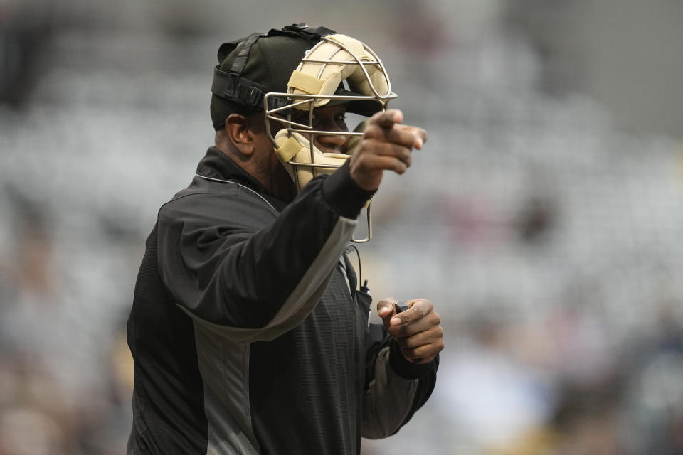 An umpire signals for a strike after being told a strike call through an earpiece during the first inning of a minor league baseball game between the St. Paul Saints and the Nashville Sounds, Friday, May 5, 2023, in St. Paul, Minn. Automatic balls and strikes could soon be coming to the major leagues. Much like the players themselves, robo-umps are working their way up through the minors with the goal being promoted to the show. (AP Photo/Abbie Parr)