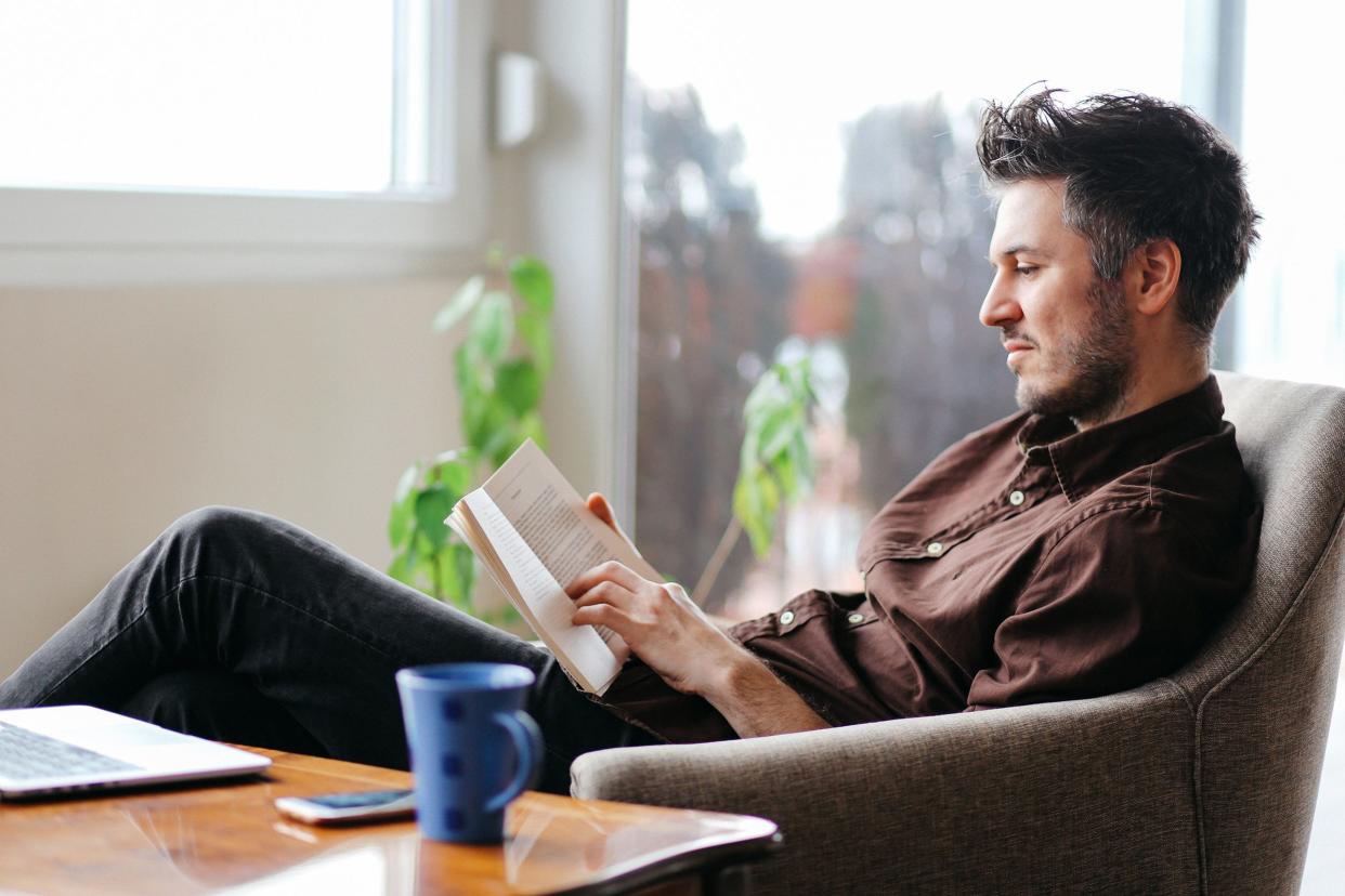 Man sitting at home reading a book