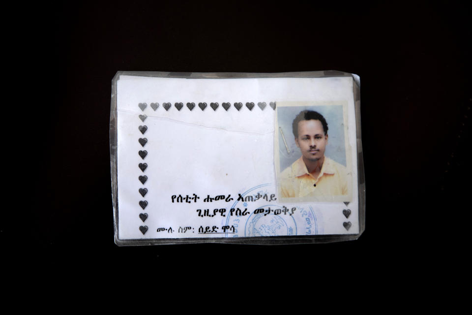 This March 17, 2021 photo shows a new ID card issued by Amhara authorities to Seid Mussa Omar, a 29-year-old Tigrayan nurse from Humera, who fled to Hamdayet, eastern Sudan, near the border with Ethiopia. Amhara authorities took Omar's original ID card displaying his Tigrayan ethnicity and burned it, he said. On the new card examined by the AP, traces of Tigray had vanished. It was issued in January 2021 in a city located so far north in Ethiopia that it is within sight of neighboring Eritrea. Yet the card is stamped by authorities of the Amhara region to the south. The language on the card is Amharic, not the Tigrinya of Tigray. Translation from Amharic reads, "Setit Humera General Temporary Work Place Identity — Full Name: Seid Mussa." (AP Photo/Nariman El-Mofty)