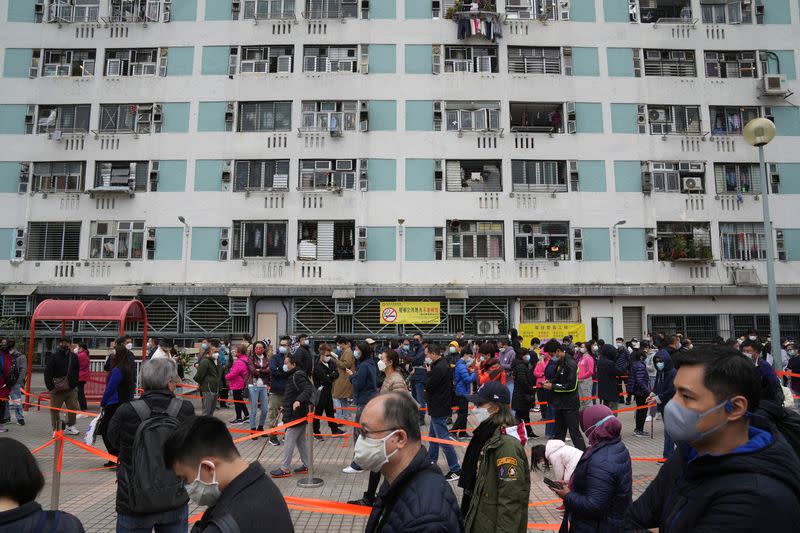 People wearing face masks queue at a community nucleic acid testing centre for the coronavirus disease (COVID-19) at Sha Tin district, in Hong Kong