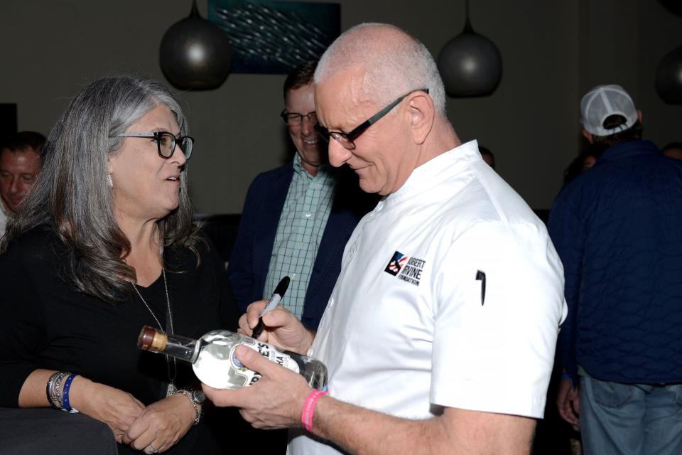 Celebrity chef Robert Irvine autographs a bottle of his Irvine's Spirits during a Palm Beach Food & Wine Festival event at a Okeechobee Steakhouse-related banquet hall Thursday, Dec. 7.