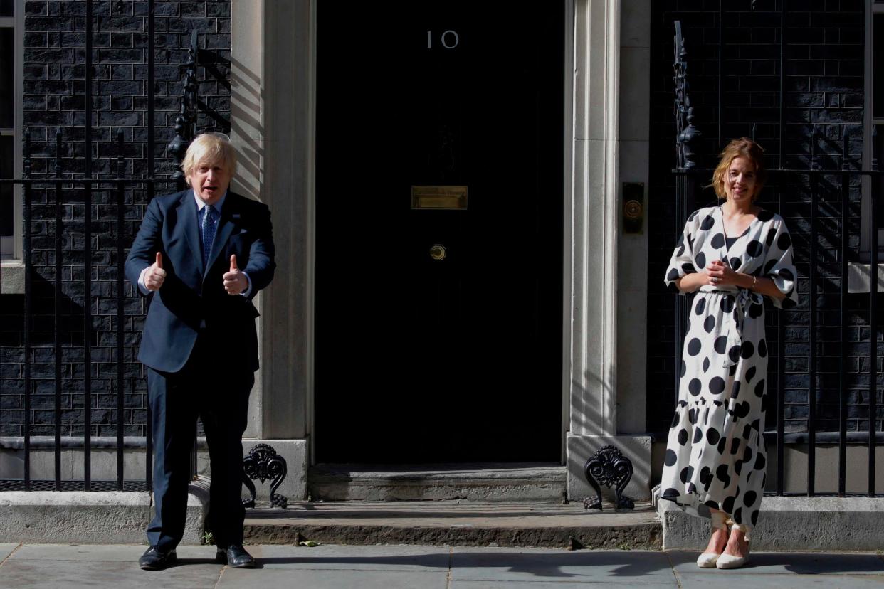 Britain's Prime Minister Boris Johnson (Left) and Clap for Carers founder Annemarie Plas (Right) participate in a national NHS celebration clap outside 10 Downing Street: AFP via Getty Images