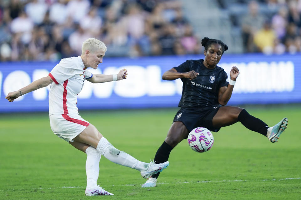 OL Reign forward Megan Rapinoe, left, clears the ball as Angel City FC defender Jasmyne Spencer defends during the second half of an NWSL soccer match, Sunday, Aug. 27, 2023, in Los Angeles. (AP Photo/Ryan Sun)