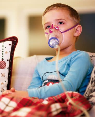 FILE PHOTO: Weston Tuttle, 5, does a nebulizer treatment while watching "Frosty the Snowman" at their home in Steilacoom, Washington, U.S. November 28, 2018. REUTERS/Lindsey Wasson/File Photo