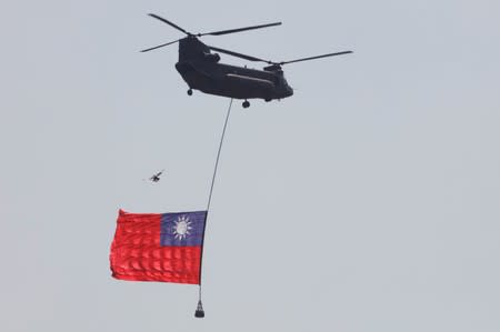 A helicopter carries a Taiwan national flag are seen during the National Day celebrations in Taipei