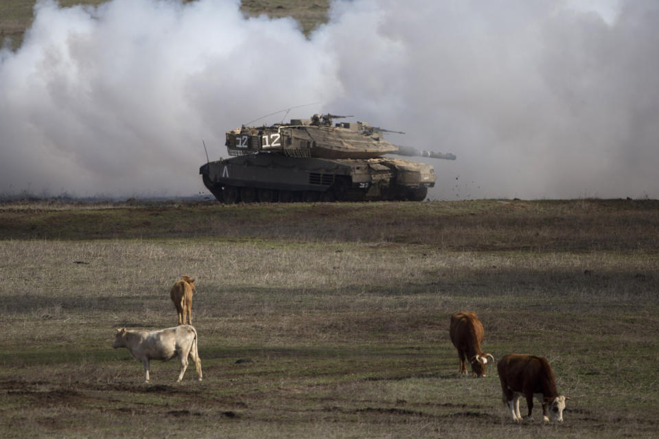 FILE - In this Jan. 11, 2016, file photo, an Israeli Merkava Mark 4 tank drives close to livestock during an exercise in the Israeli-controlled Golan Heights, near the border with Syria. President Donald Trump’s move to recognize Israeli sovereignty over the Golan Heights turns the tables on decades of U.S. diplomacy and international law and threatens to further inflame regional tensions. (AP Photo/Ariel Schalit, File)