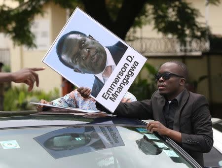 A protester holds a poster showing support for ousted Zimbabwean vice-President Emmerson Mnangagwa, in Harare, Zimbabwe, November 18, 2017. REUTERS/Philimon Bulawayo