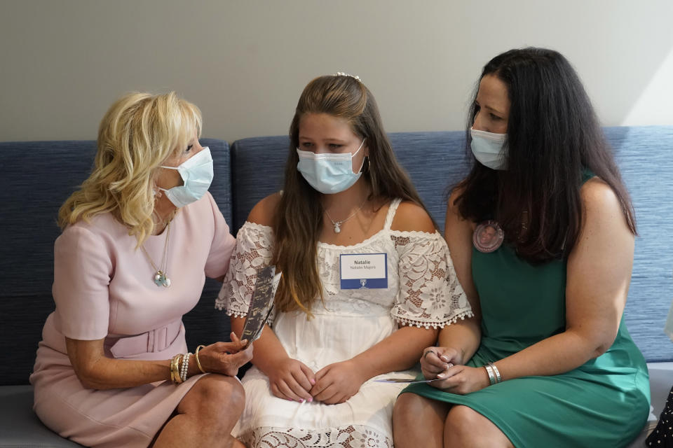 FILE - First lady Jill Biden, left, speaks with Natalie Majors, center, and her mother Katie Langer, right, during a visit to Home Base, a Red Sox Foundation and Massachusetts General Hospital program designed to help veterans and families with PTSD and traumatic brain injuries, or TBI, in Boston, July 14, 2022. Langer went through a PTSD program for families who have lost a service member. (AP Photo/Steven Senne, File)