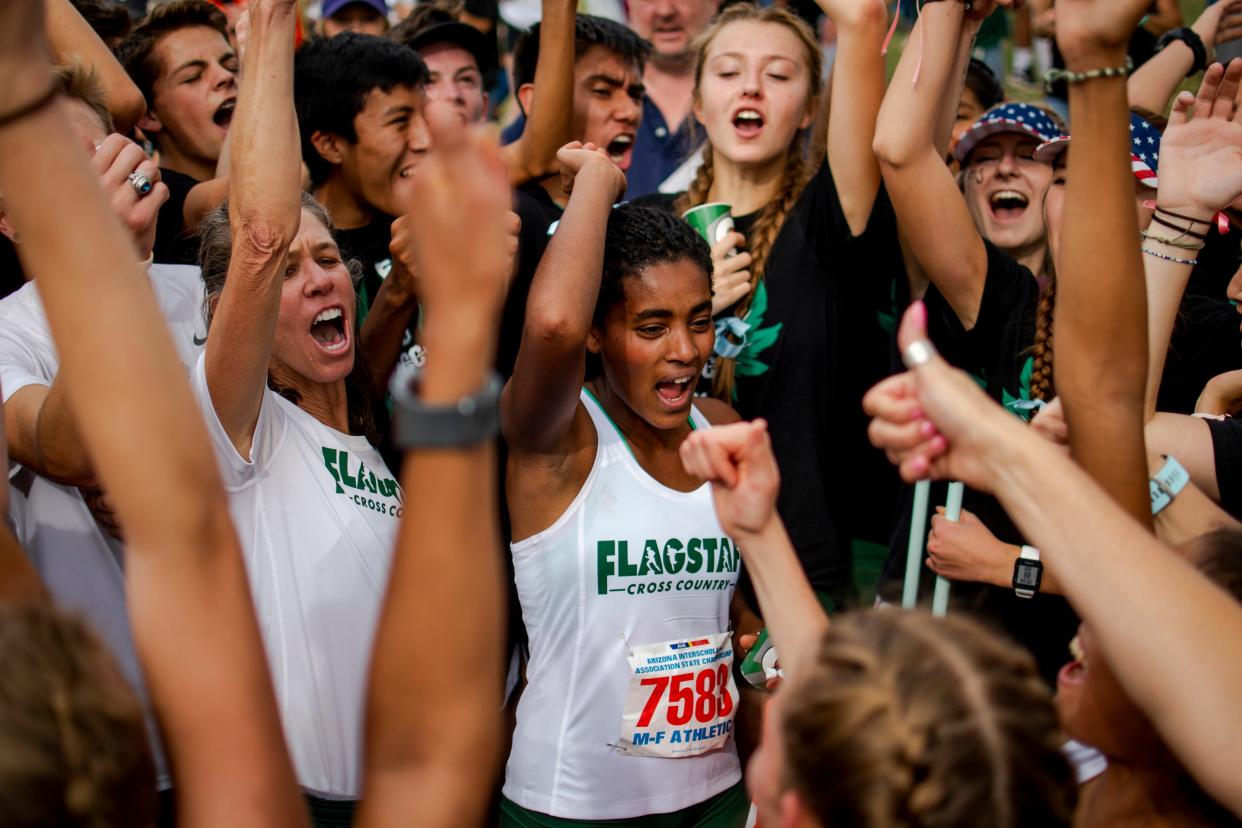 The Flagstaff girls cross country team celebrates winning a fifth consecutive state title during the state cross-country championships at Cave Creek Golf Course in Phoenix on Friday, Nov. 15, 2019.