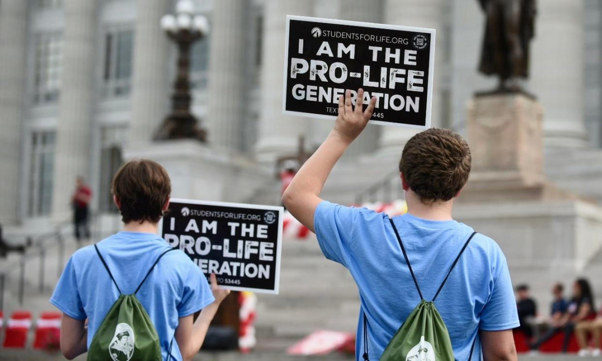 Students hold up anti-abortion signs at the Midwest March for Life on Wednesday at the Missouri State Capitol.